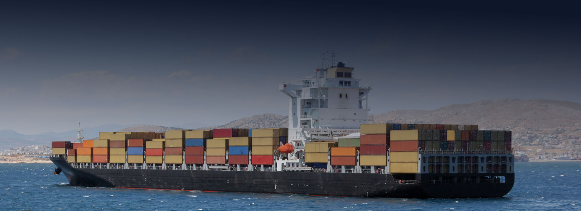 cargo ship in the ocean carrying multi coloured containers